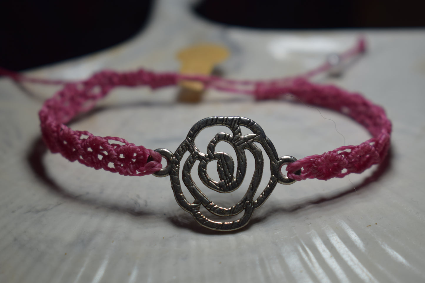 Bracelet en macramé rose avec pendentif en forme de rose ajourée en métal
